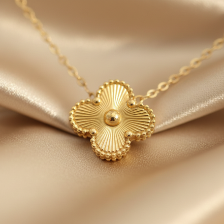 Gold necklace with a floral pendant on a beige fabric background