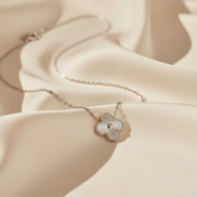 Delicate necklace with a heart-shaped pendant on a soft beige fabric background
