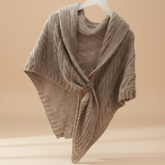Knitted beige shawl on a hanger against a beige background
