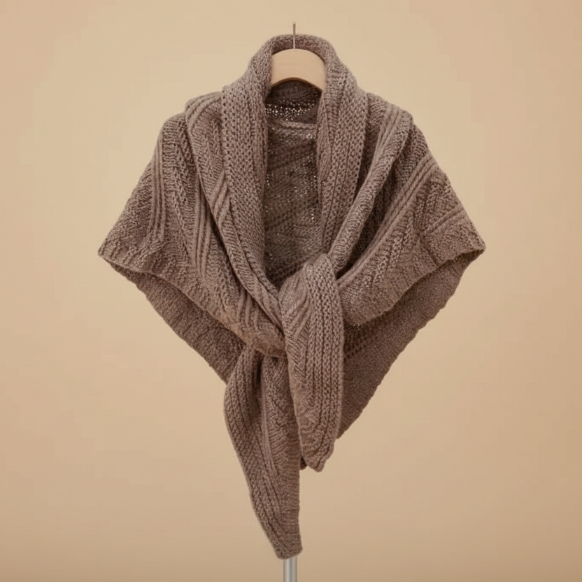 Brown knitted shawl on a hanger against a beige background