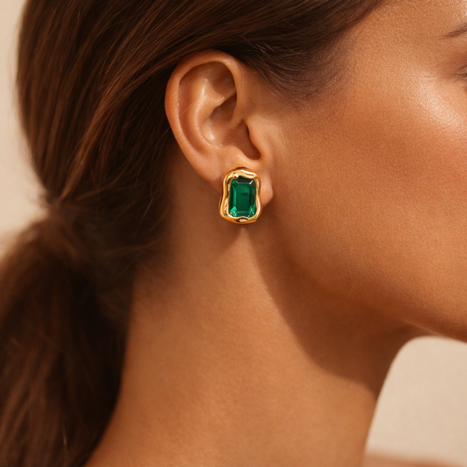 Chunky irregular gold stud earrings with bold emerald green rectangular gemstone center, waterproof hypoallergenic stainless steel, shown from front and side angle