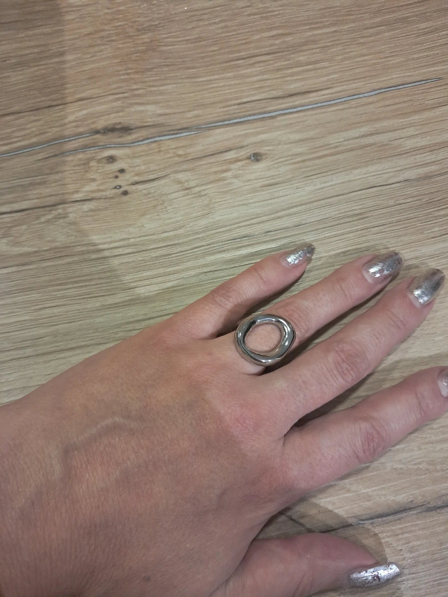 Silver abstract oval ring worn on a hand