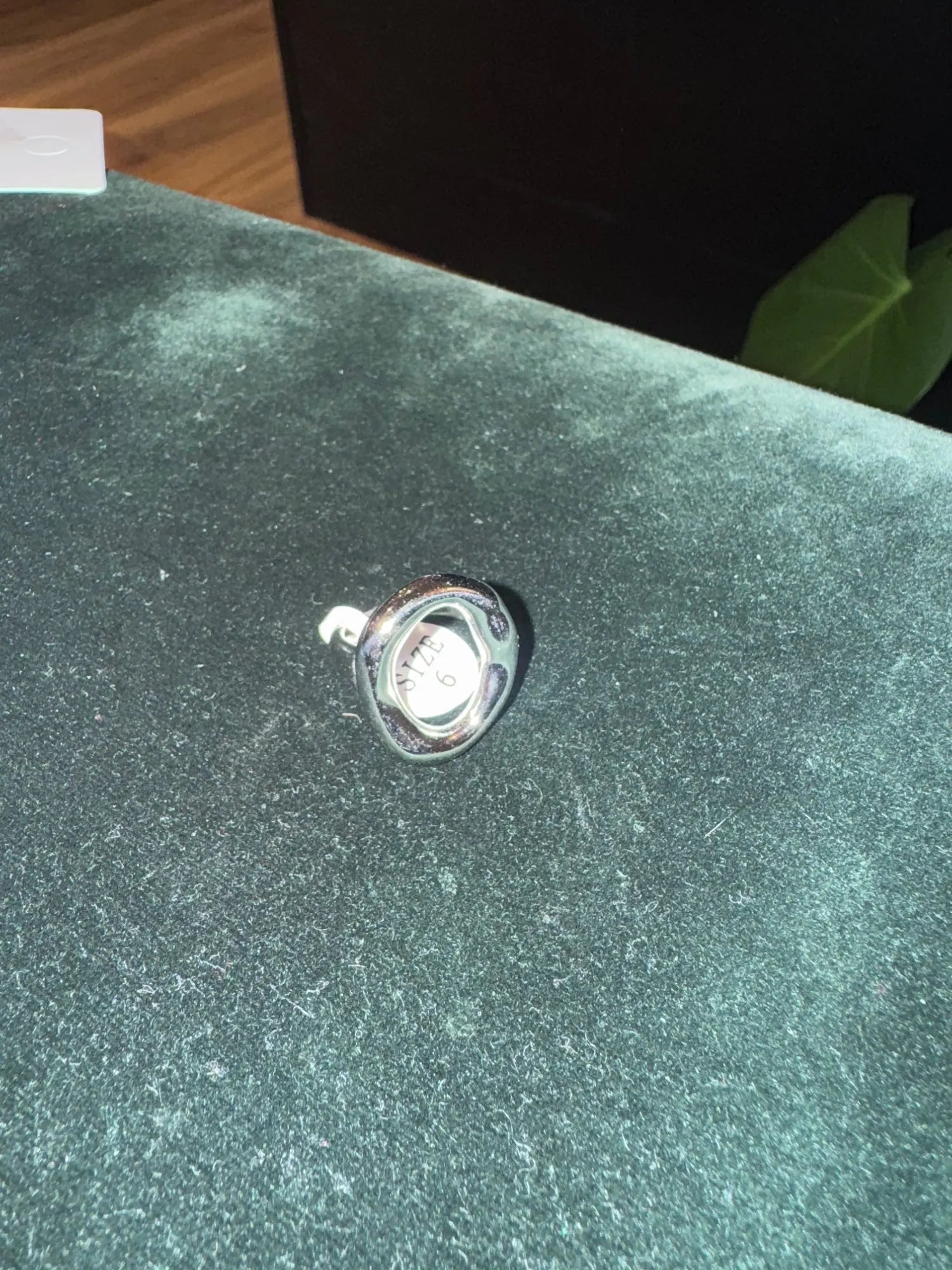 Silver abstract oval ring photographed on fabric