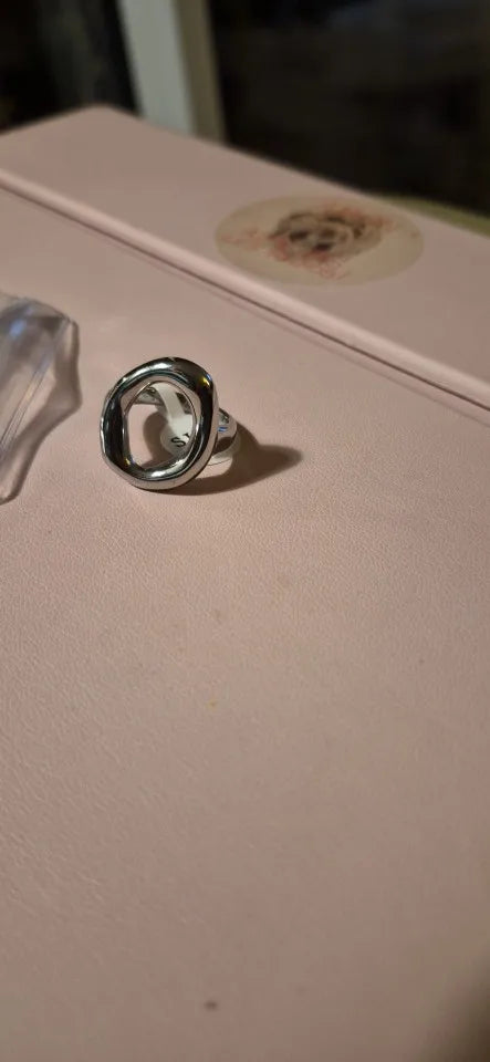 Silver abstract oval ring photographed from the side