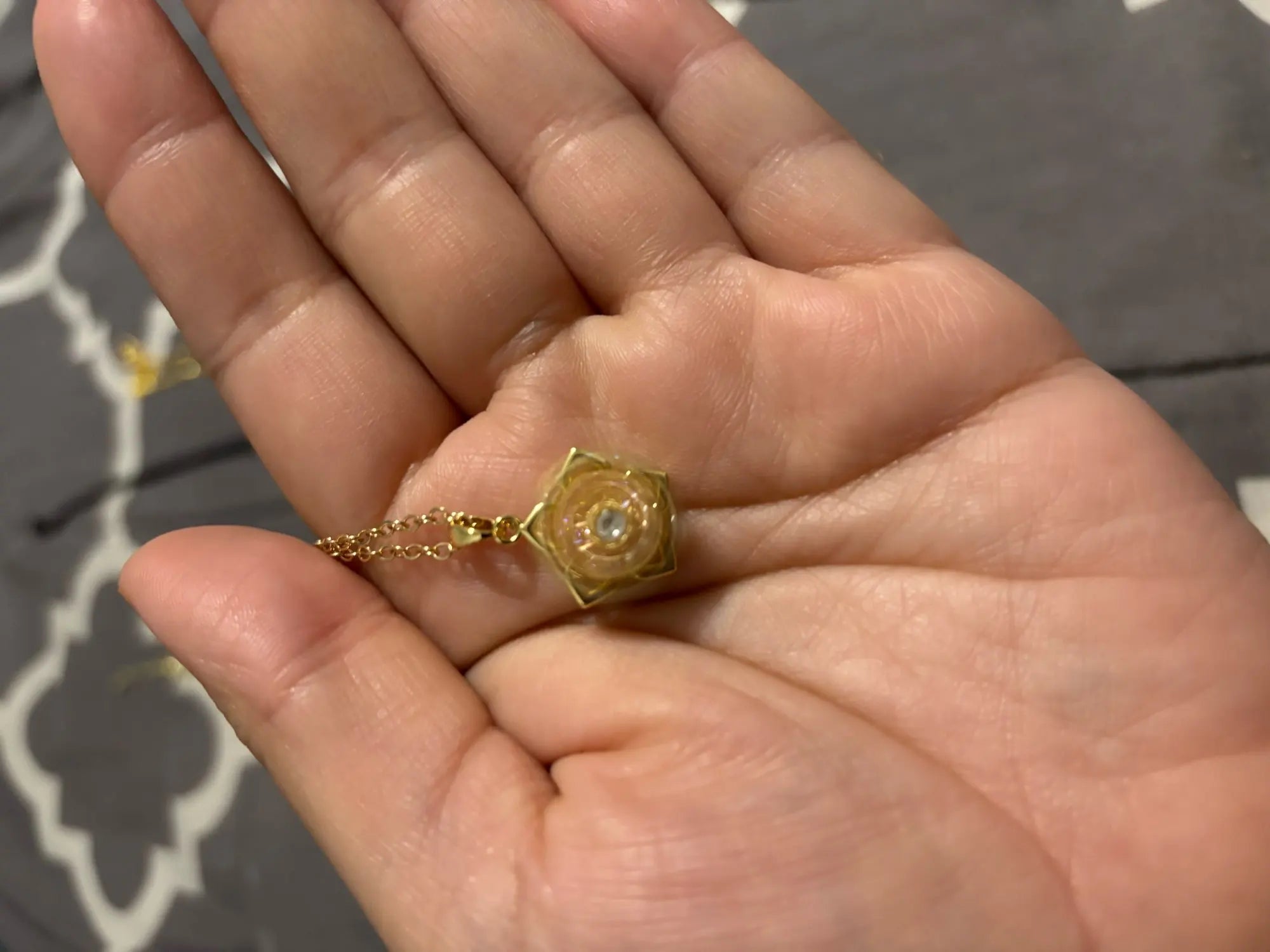 Back of the rotating flower pendant in a customer’s hand