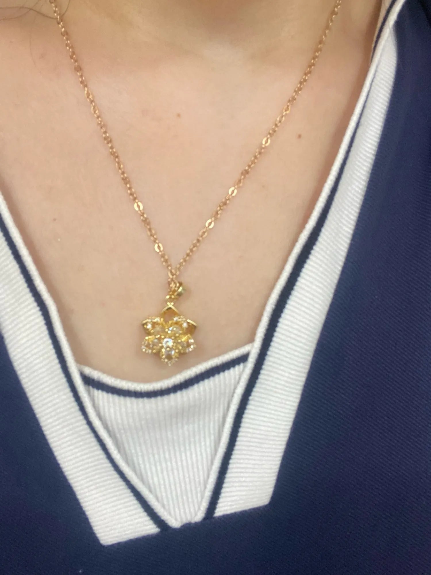 Clear rotating flower pendant worn by a customer