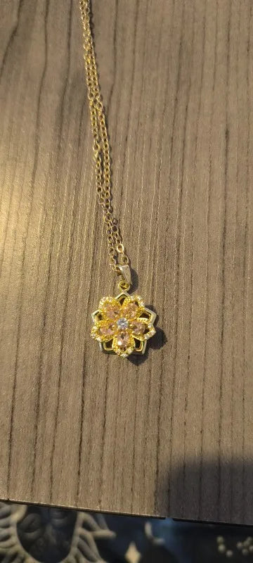 Pink rotating flower pendant displayed by a customer